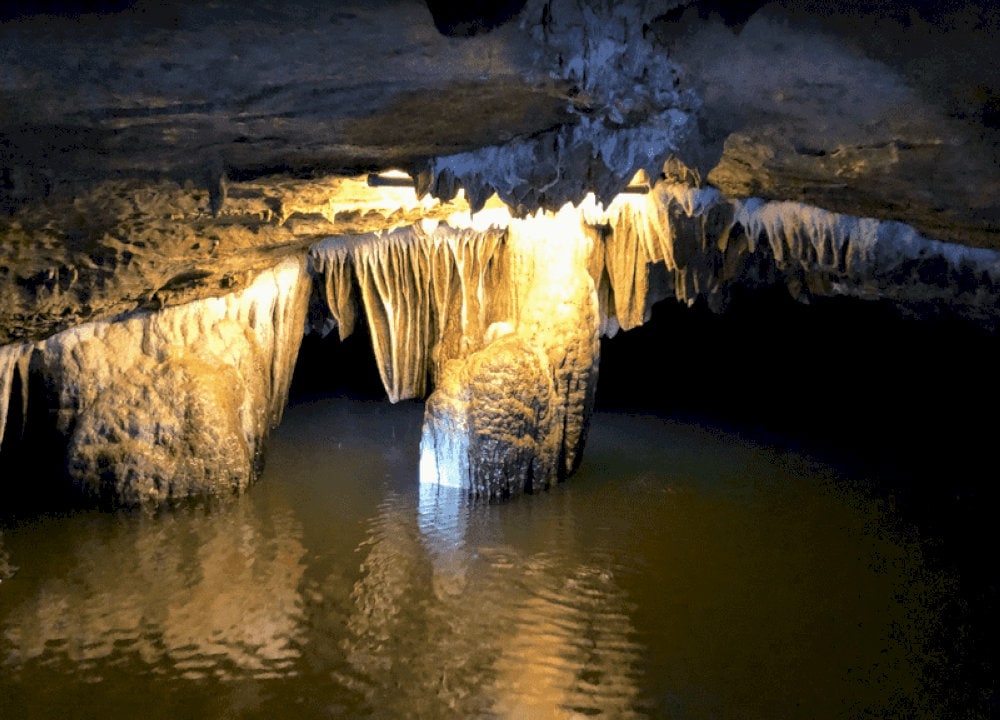 The path leading into Dark Cave is winding and narrow, with little to no natural light reaching inside, hence its name given by the locals